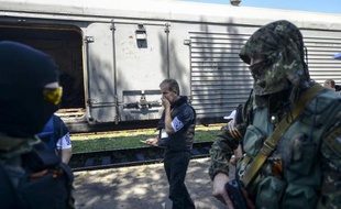 Des enquêteurs européens examinent les restes de corps de victimes du vol MH17 dans un train bloqué par les rebelles à Torez en Ukraine, le 21 juillet 2014