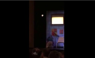 Capture d'écran d'une vidéo YouTube montrant un homme monter sur scène au Booth Theater à Broadway pour recharger son portable, le 3 juillet 2015.