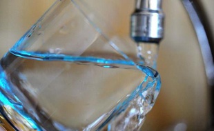 Un verre d'eau sous un robinet