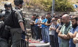 Des hommes font face aux policiers israéliens, qui interdisent aux hommes de moins de 50 ans d'accéder à la vieille ville de Jérusalem
