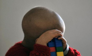 Un enfant de quatre ans, traité pour un cancer, en train de jouer dans une unité de soins.