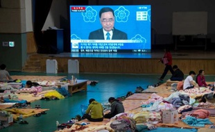 Des familles des victimes du naufrage du ferry Sewol regardent à la télévision le Premier ministre Chung Hong-Won annonçant sa démission le 27 avril 2014 à Jindo