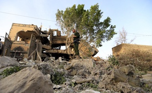 Un soldat dans lesruines d'une maison touchée par les raids de la coalition emmenée par l'Arabie Saoudite près de Sanaa, la capitale yéménite