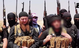 Photo fournie le 29 juin 2014 par le média jihadiste Al-Itisam montrant des personnes présentées comme des membres de l'Etat islamique (EI), photographiées dans la zone frontalière entre Irak et Syrie