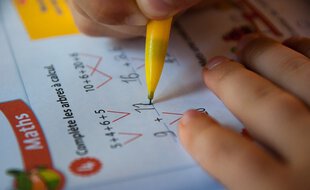Un écolier de primaire qui fait un exercice de maths.