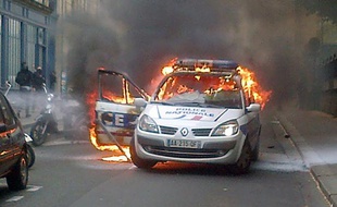 Photo prise par téléphone portable d'une voiture de police incendiée lors d'une contre-manifestation à Paris le 18 mai 2016