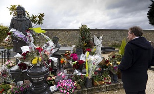 Le 17 mars 2013, un homme se recueille sur la tombe du chanteur Claude François qui a été vandalisée la veille dans le cimetière de Dannemois (Essonne).
