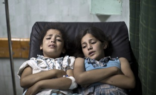 Deux Palestiniennes blessées attendent d'être soignées à l'hôpital Kamal Adwan à Beit Lahia au nord de Gaza, le 30 juillet 2014.