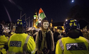 Des manifestants anticapitalistes, portant pour certains le masque des Anonymous, font face aux forces de l'ordre à Londres le 5 novembre 2014