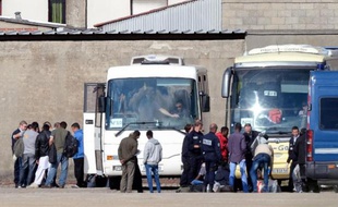 Des policiers français conduisent des clandestins expulsés de leur camp à Calais pour les amener dans un centre de rétention, le 2 juillet 2014