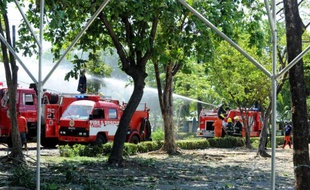 Des pompiers tentent d'éteindre un incendie dans un dépôt de munitions d'armes à Manille, aux Philippines, le 7 mai 2014