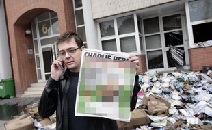 Stéphane Charbonnier, alias Charb, montrant une couverture de Charlie, le 2 novembre 2011. La photo a été floutée par des médias, comme Daily News.