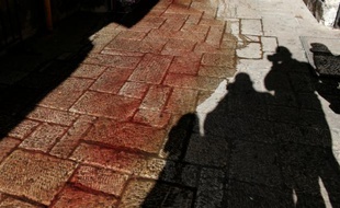 Les ombres de photographe prenant en photo des tâches de sang sur le sol après qu'un Palestinien a poignardé un policier israélien à Jérusalem le 29 novembre 2015