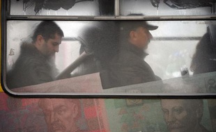 Des passagers sont assis le 2 décembre 2008 à Kiev dans un bus recouvert de reproductions de billets de la monnaie ukrainienne, la hryvnia