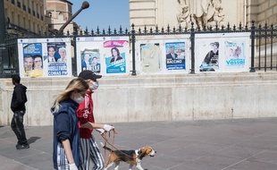 Des promeneurs passent devant les affiches des candidats aux municipales à Marseille, en avril 2020.