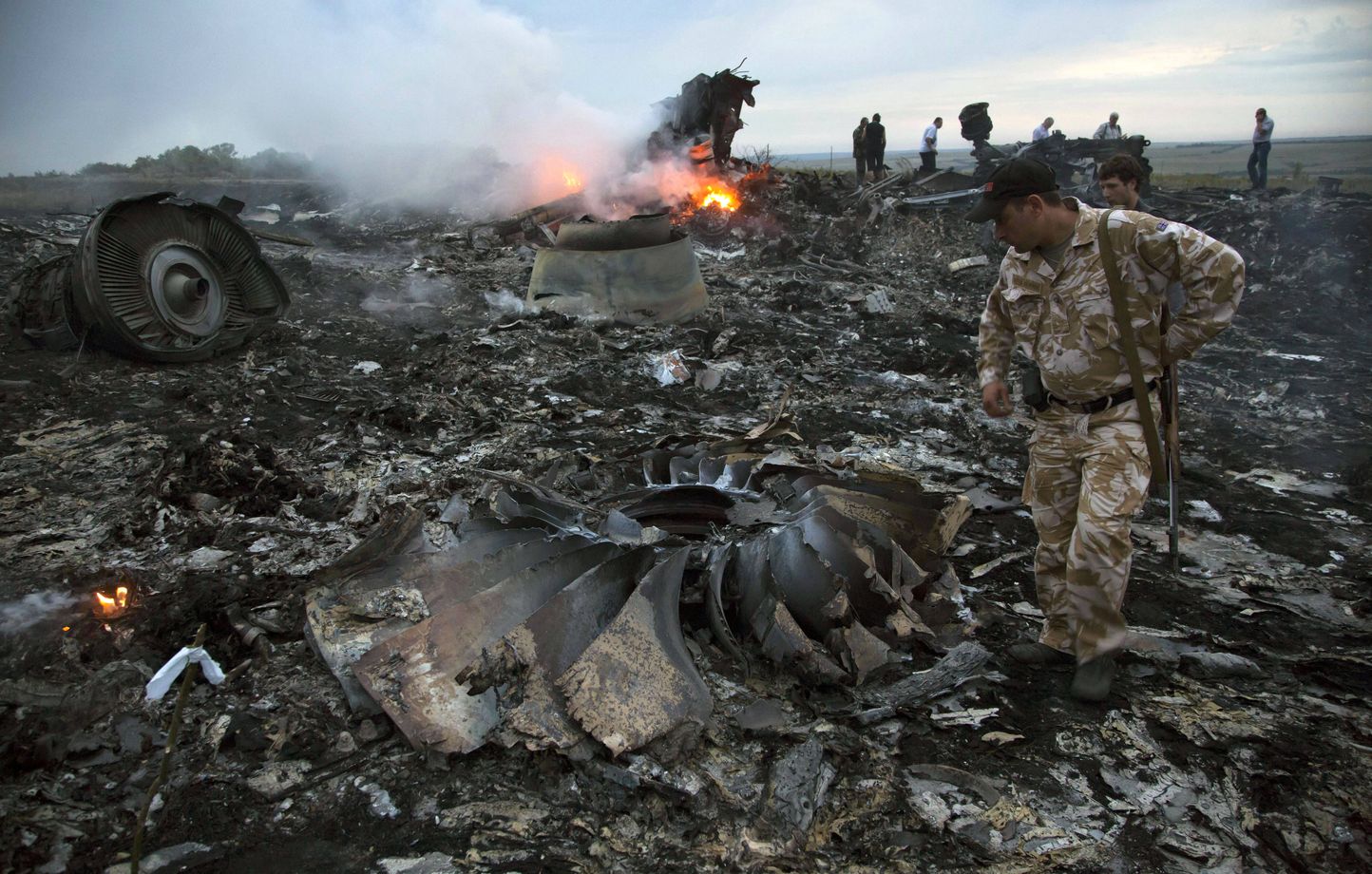 Des personnes marchent parmi les débris sur le site du crash d'un avion de ligne près du village de Grabovo, en Ukraine, le 17 juillet 2014.