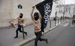 Des militantes Femen amènent devant la Grande Mosquée de Paris un drapeau présenté comme «salafiste» avant d'y mettre le feu, le 3 avril 2013.
