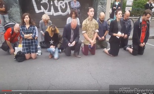 Douze personnes prient agenouillés dans la rue devant l'église Sainte-Rita (15e).