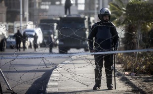 Des policiers anti-émeute postés devant l'académie de police du Caire où comparaît l'ancien président Mohamed Morsi, le 28 janvier 2014