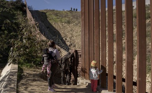 Les officiers de la patrouille frontalière, en haut, observent le groupe de migrants mexicains qui se préparent à franchir la barrière de la frontière pour se rendre du côté américain à San Diego, en Californie, depuis Tijuana, au Mexique. Découragés par la longue attente pour demander l'asile par les points d'entrée officiels, de nombreux migrants choisissent de franchir le mur frontière américain et de se rendre aux agents de la patrouille frontalière.