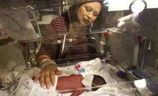 Tressa Montalvo places her hand on her newborn son, Blaine, at The Women's Hospital of Texas on Monday, Feb. 18, 2013, in Houston. Montalvo gave birth to two sets of identical twins on Valentine's Day, born at 31 weeks. The arrival of Ace and Blaine then Cash and Dylan a minute later was even more unusual because the Montalvos did not take fertility drugs or use in-vitro fertilization.