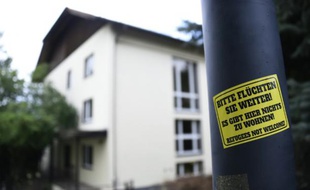 Un sticker apposé sur un lampadaire clame, le 27 juillet 2015 à Freital, en Saxe: "S'il vous plaît, fuyez un peu plus loin! Il n'y a rien pour vous accueillir ici! Les réfugiés ne sont pas les bienvenus!"