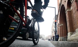 Un cycliste et une voiture dans le centre ville de Toulouse (illustration).