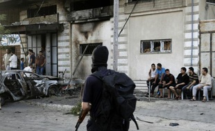 Des palestiniens se rassemblent autour d'une voiture brûlée le 19 juillet 2015, après cinq attentats coordonnés qui visaient des membres du Hamas et du Jihad islamique à Gaza
