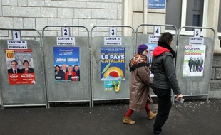 Des électeurs passent devant des affiches électorales, le 22 mars 2015 à Perpignan