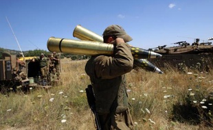 Un soldat israélien amène des muntions à un char positionné à un point de contrôle à la frontière entre Israël et la Syrie, sur le plateau du Golan, le 22 juin 2014