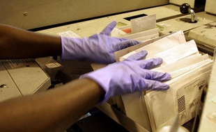 Un employé postal trie du courrier avec des gants, le 17 octobre 2001, à New York.