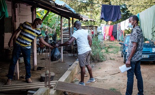 Des bénévoles distribuent de l'aide alimentaires aux familles dans le besoin à Cayennes, en Guyane durement frappée par le coronavirus et confinée depuis des mois.