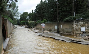 Un homme marche le long d'une rue inondée à Nimes le 10 octobre 2014 à la suite d'intempéries