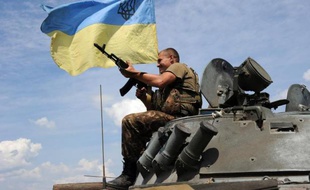 Un soldat ukrainien sur son char, mitraillette en main, à quelque 20 km de Donetsk, le 10 juillet 2014