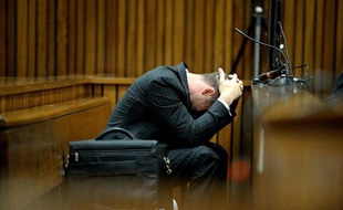 L'athlète paralympique sud-africain Oscar Pistorius, accusé du meurtre de sa petite amie, prostré durant le compte-rendu d'autopsie de Reeva Steenkamp lors de son procès à Pretoria le 10 mars 2014