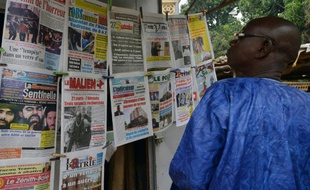 Un homme regarde les unes des journaux maliens, le 23 novembre 2015 à Bamako