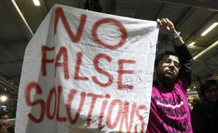 Un manifestant brandit une bannière "Pas de fausses solutions", au Bourget, à Paris, le 9 décembre 2015