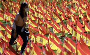 Une femme se promène dans le Roma Park à Madrid, où des milliers de drapeaux ont été disposés pour rendre hommage aux victimes du Covid-19.