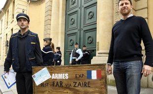 Deux membres de l'association Survie portent une caisse d'armes factice, le 5 avril 2018.