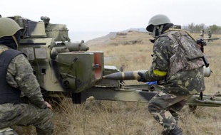 Un soldat ukrainien charge un obus dans un canon d'artillerie près de Marioupol