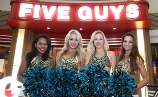 Des pom-pom girls devant un restaurant Five Guys