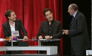 Capture vidéo de Gérard Collomb (à dr.) et de Laurent Gerra (au centre) chantant Eddy Mitchell. Emission diffusée sur Paris Première le 26 novembre 2010.