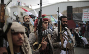 Les partisans des Houthis tiennent leurs armes alors qu'ils assistent à un rassemblement pour marquer le septième anniversaire de la prise de contrôle par les Houthis de la capitale yéménite, à Sanaa, au Yémen, le mardi 21 septembre 2021.