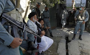 Des policiers afghans montent la garde à l'extérieur d'un bureau de vote de Kaboul le 18 septembre 2010.