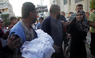Un Palestinien porte le corps de sa fille de 5 ans, tué lors d'un raid israélien à Rafah, le 4 août 2014