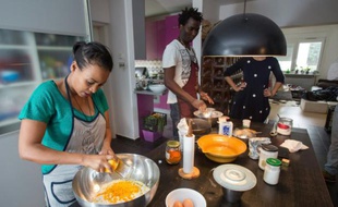 Chichi Amare (g), originaire d'Ethiopie, et David Ajobi, un ancien étudiant en médecine du Nigeria, préparent du pain le 27 octobre 2015 à Zagreb, dans le cadre d'un projet qui vise à aider les migrants à s'installer dans un nouveau pays