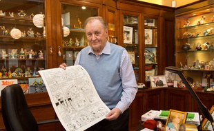 Albert Uderzo pose avec la planche originale des «Lauriers de César» vendue aux enchères au profit des familles des victimes des attentats à Charlie Hebdo le 15 janvier 2015.