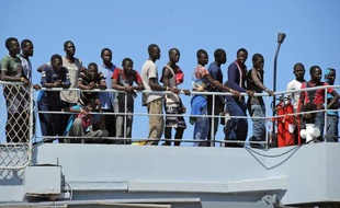 Un groupe de plus de 1,700 migrants descend d'un navire de l'armée italienne à Reggio Calabria, après avoir été récupérés en mer Méditerranée, le 11 août 2014