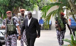 Le général Brunot Dogbo Blé (en costume) lors de son arrivée à son procès en 2014 à Abidjan. Il est l'un des 14 militaires proches de Gbagbo qui seront jugés pour les violences commises lors de la crise post-électorale de 2010-2011