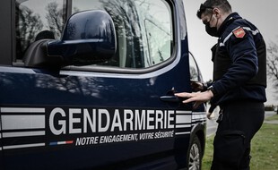 Un gendarme et une voiture de gendarmerie. (illustration)
